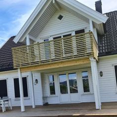Hvitt hus med påbyggd veranda